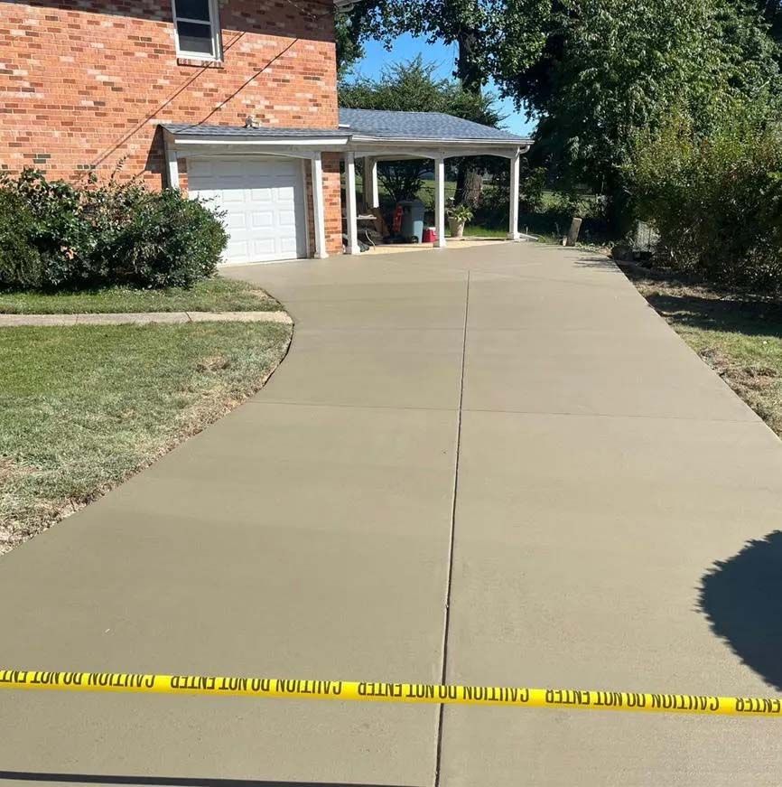 Concrete driveway to a single-car garage, repaired and resealed.